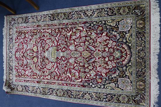 An Indian silk red ground rug